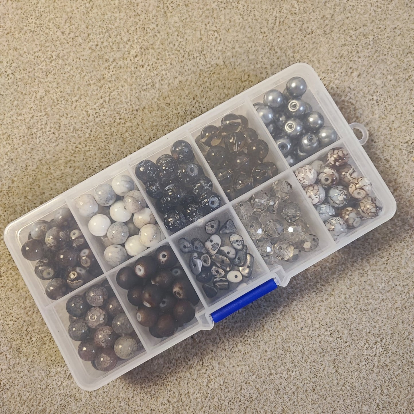Boîte de 10 compartiments de perles en verre – Tons noirs/gris et marrons – Environ 200 perles