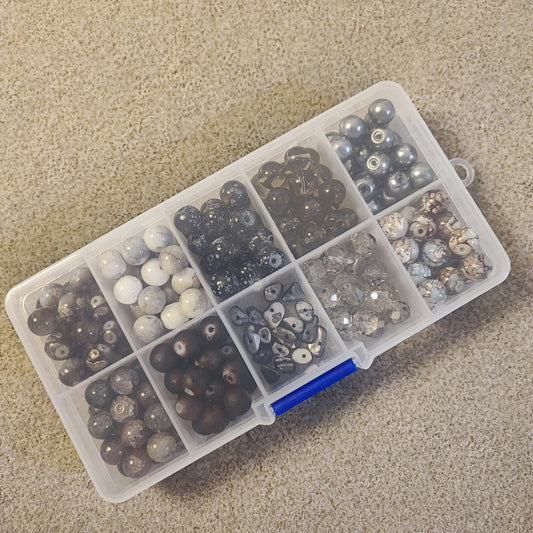 Boîte de 10 compartiments de perles en verre – Tons noirs/gris et marrons – Environ 200 perles